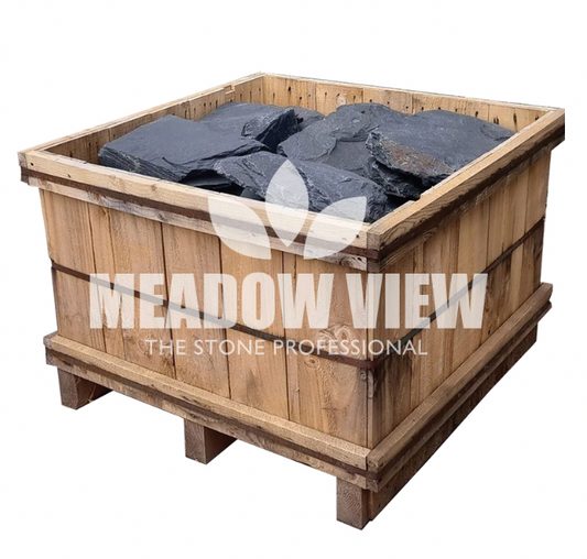 Wooden crate filled with large Black Slate Rockery stones (250mm), branded with "Paving Shopper" on the front.