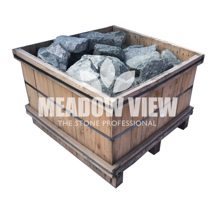 A wooden crate filled with Craig Green Rockery - 250mm large gray rocks. The crate displays the text "Paving Shopper" along with a decorative leaf logo.