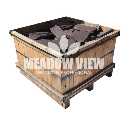 Wooden crate filled with large, flat pieces of Plum Slate Rockery - 250mm, labeled "Paving Shopper, The Stone Professional.