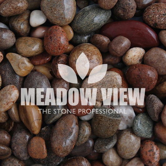 A collection of smooth, variously colored stones labeled "Scottish Pebbles - 20-30mm" by Paving Shopper, featuring the text "MEADOW VIEW THE STONE PROFESSIONAL" and a leaf logo overlaying the image.